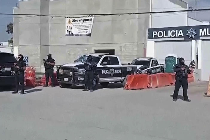 In this image made from video, Mexico's police officers stand guard at the Ensenada station in Ensenada, Mexico, Thursday, May 2, 2024. Mexican authorities said Thursday they have found tents and questioned a few people in the case of two Australians and an American who went missing over the weekend in the Pacific coast state of Baja California.
