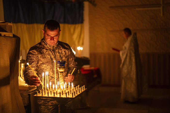An Ukrainian serviceman of the 72nd Separate Mechanized Brigade, lights candles during a Christian Orthodox Easter religious service, in Donetsk region, Ukraine, Saturday, May 4, 2024.