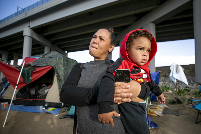 Rosbely Sira Linarez holds her infant son on April 24 in the north Denver encampment where they've been living with other South and Central American immigrants who arrived in Colorado in the last year.