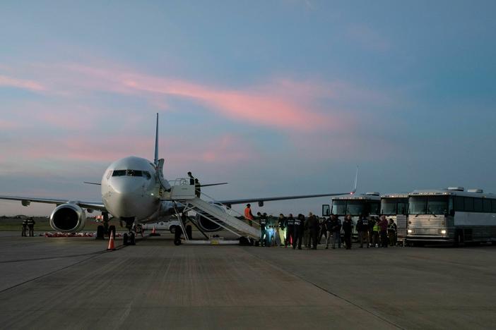In this file photo, migrants board a plane in Harlingen, Texas, on October 18, 2023 for deportation to Venezuela.