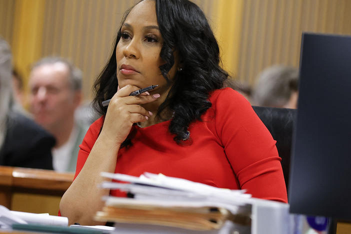 Fulton County District Attorney Fani Willis listens during the final arguments in her disqualification hearing on March 1 in Atlanta. She was allowed to remain on the case if a special prosecutor she hired resigned.