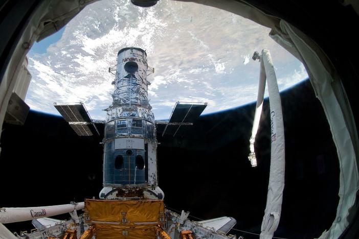 The Hubble Space Telescope in 2009, locked in a space shuttle's cargo bay, before the final repair work ever done.
