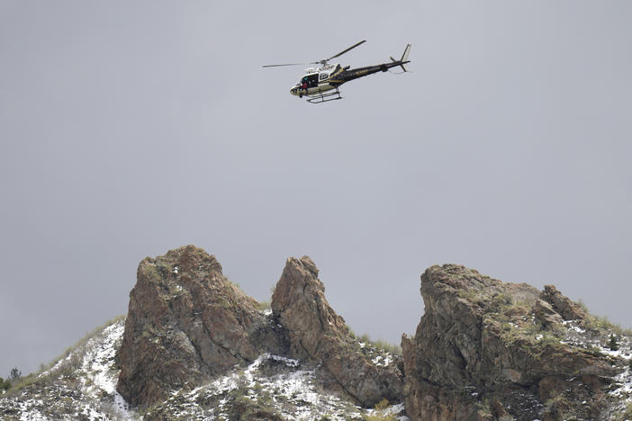 A Utah Department of Public Safety helicopter carries rescuers from Hidden Valley Park on Thursday in Sandy, Utah.