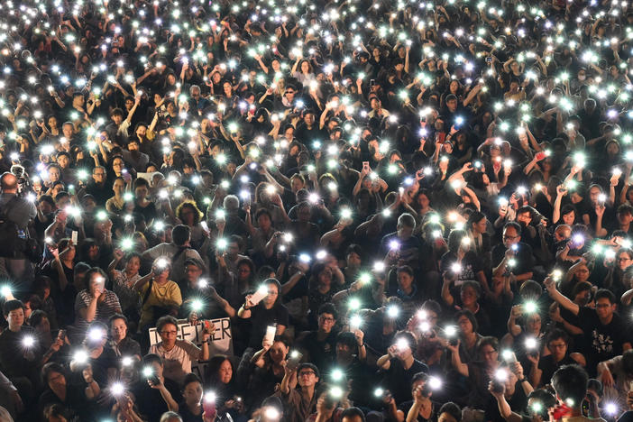 Demonstrators hold up lights from their phones during a rally organized by Hong Kong mothers in support of extradition law protesters, in Hong Kong on July 5, 2019.