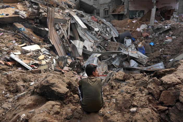 A Palestinian boy sits near the rubble of a residential building destroyed in an Israeli strike in Al-Zawayda in the central Gaza Strip on Saturday.