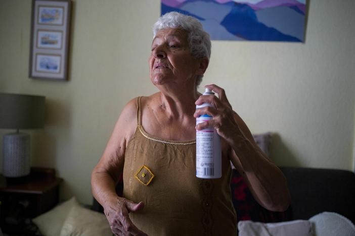 Jackye Lafon, who's in her 80s, cools herself with a water spray at her home in Toulouse, France during a heat wave in 2022. Older people face higher heat risk than those who are younger. Climate change is making heat risk even greater.