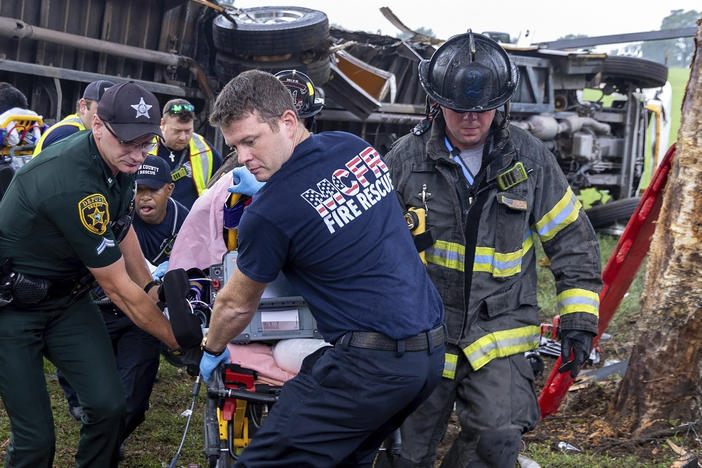 Crews from Marion County Fire Rescue and the Marion County Sheriff's Office assist victims after a bus carrying farmworkers crashed and overturned early Tuesday Ocala, Fla.