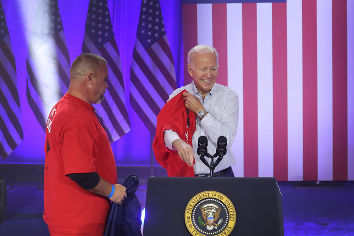 President Biden puts on a United Auto Workers t-shirt in Belvidere, Ill. on Nov. 9, 2023. Biden on Tuesday is announcing new tariffs on imports of Chinese goods, including electric vehicles.