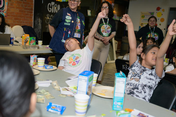 The girls excitedly raise their hands during an activity at Girl Scout Troop 6000's weekly meeting at the Row Hotel on Wednesday evening.