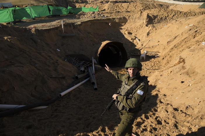 Israeli military spokesman Rear Adm. Daniel Hagari stands at the opening to a tunnel near the border with Israel on Dec. 15, 2023, northern Gaza Strip. The Israeli military said this was the largest tunnel they'd found yet in Gaza.