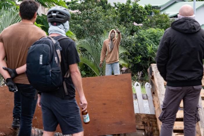 Masked residents watch an activist in Nouméa on Wednesday.