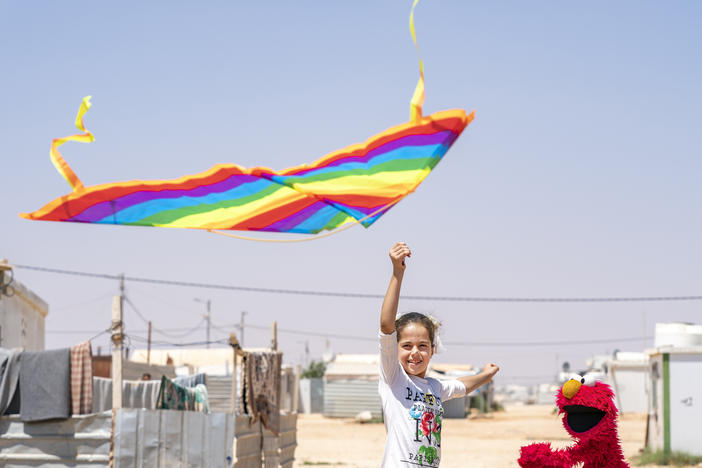 In 2017, Sesame Workshop and the International Rescue Committee became the first winners of 100&Change for their work with children in the Middle East<em>.</em> Above, Elmo learns how to fly a kite at Azraq Camp, Jordan.