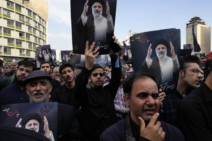 People hold up posters of Iranian President Ebrahim Raisi during a mourning ceremony for him on Monday at Vali-e-Asr square in downtown Tehran, Iran.