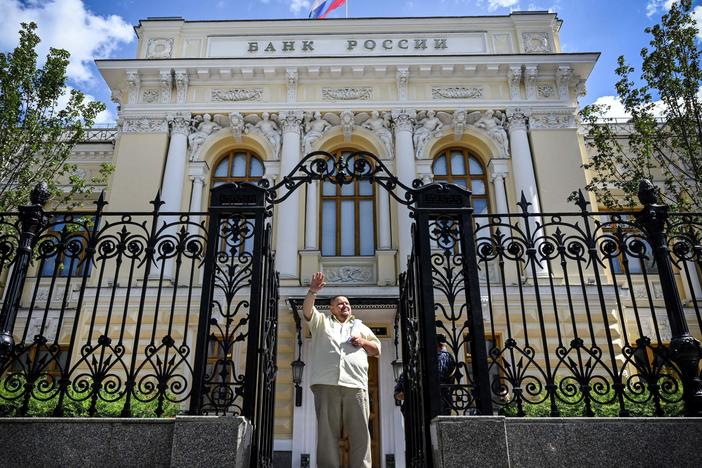 A man waves to a taxi as he leaves the Russian Central Bank headquarters in downtown Moscow last summer. The EU approved a plan this week to use interest from hundreds of billions of dollars' worth of seized Russian assets to help fund Ukraine's military.
