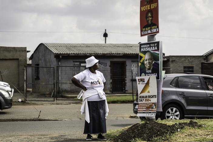 A woman wearing a shirt of African Congress for Transformation party looks at other parties' election posters in Sharpeville, South Africa, on March 21.