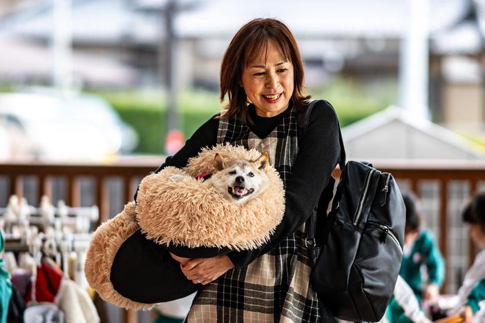 Atsuko Sato is seen with her Japanese shiba inu dog Kabosu, best known as the logo of cryptocurrency Dogecoin, playing with students at a kindergarten in Narita, Chiba prefecture, east of Tokyo, on March 19.