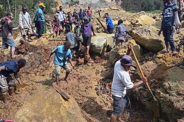 Villagers search through a landslide in Yambali, in the Highlands of Papua New Guinea, on Sunday, May 26, 2024. The International Organization for Migration feared Sunday the death toll from a massive landslide is much worse than what authorities initially estimated.
