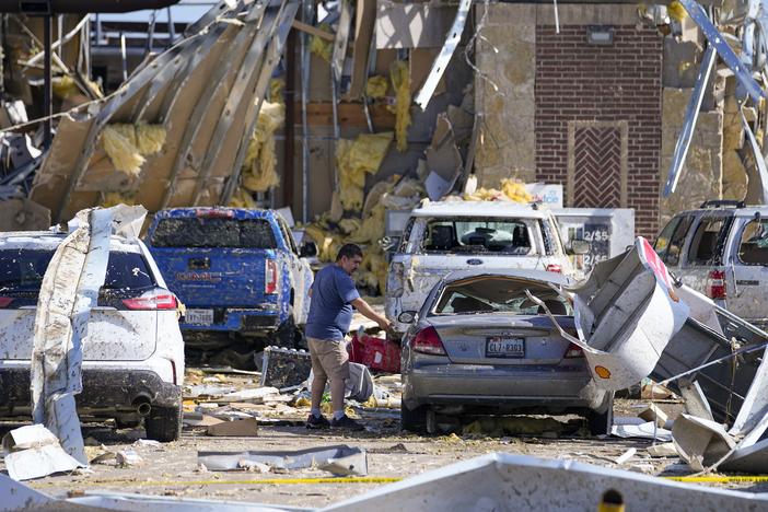 A man looks at a damaged car after a tornado hit the day before, Sunday, May 26, 2024, in Valley View, Texas. Powerful storms left a wide trail of destruction Sunday across Texas, Oklahoma and Arkansas after obliterating homes and destroying a truck stop where drivers took shelter during the latest deadly weather to strike the central U.S.