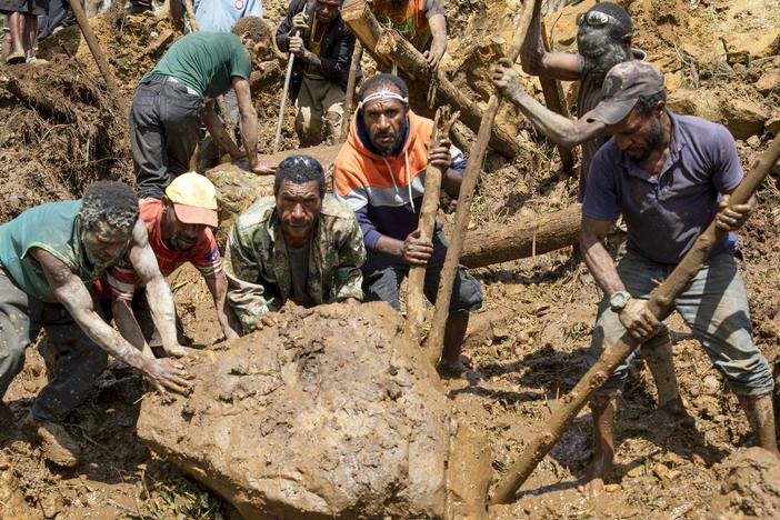 Villagers search through debris from a landslide in Yambali village in the highlands of Papua New Guinea, on Monday, May 27, 2024. Authorities fear a second landslide and a disease outbreak are looming at the scene because of water streams trapped beneath tons of debris and decaying corpses seeping downhill. 