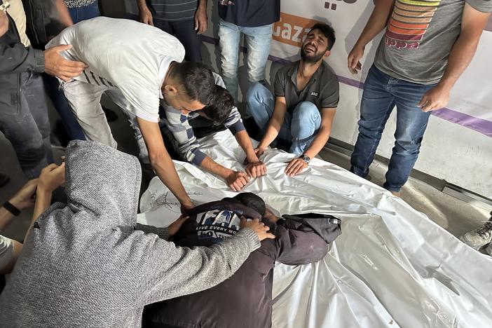 Palestinians grieve relatives who were killed in an Israeli airstrike on an encampment for displaced people on Sunday, May 26, in the southern Gaza city of Rafah.