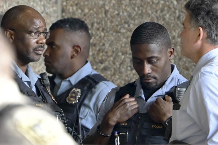 Members of law enforcement gather outside Hennepin County Medical Center in Minneapolis on Thursday following a fatal shooting.