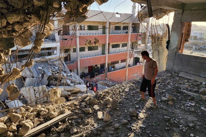  A man looks over the ledge at a bombed-out school in Khan Younis on May 24.
