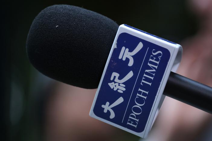 A reporter for The Epoch Times holds a microphone during a media event on Oct. 23, 2023, in Berlin, Germany. The Epoch Times is owned by Epoch Media Group and is affiliated with the Falun Gong movement.