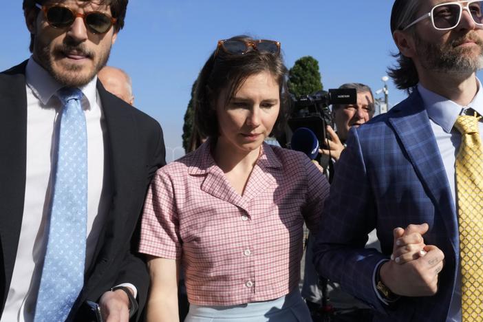 Amanda Knox arrives flanked by her husband Christopher Robinson, right, at the Florence courtroom in Florence, Italy, on Wednesday.