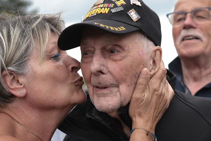 World War II veteran Gene Kleindl, age 102, from Rockford, Ill., receives a kiss from Chantell Boivin while leaving the Normandy American Cemetery on June 4 in Colleville-sur-Mer, France. Kleindl, a medic in the U.S. Army's 90th Infantry Division, arrived on the beaches of Normandy on D-Day.