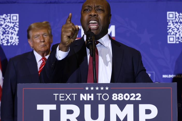Sen. Tim Scott (R-SC) speaks as Republican presidential candidate and former President Donald Trump looks on during a campaign rally on January 19 in Concord, N.H.