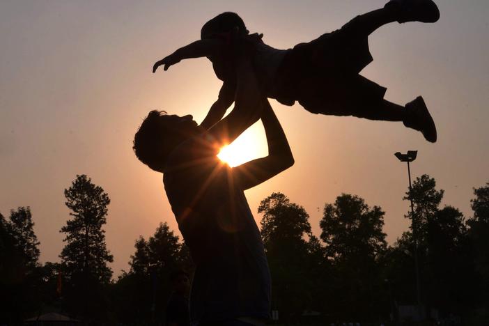 Indian father Shailesh throws up his son, Harish, at a park in Amritsar on June 19, 2016, on Father's Day, a day observed in many countries to celebrate fathers and fatherhood.