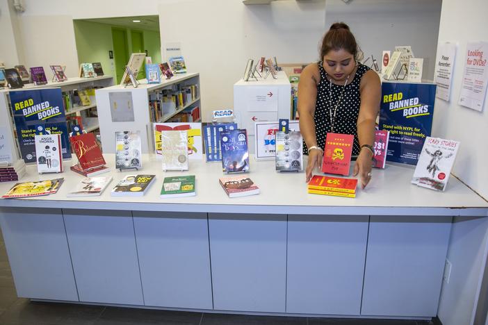 Librarian Sabrina Jesram arranges a display of books during Banned Books Week at a public library branch in New York City on Sept. 23, 2022. 