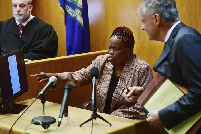 Wanda Geter-Pataky (center) talks with her lawyer, John Gulash (right), during October 2023 testimony in a challenge of absentee ballots in the 2023 Bridgeport, Conn., mayoral Democratic primary. Geter-Pataky was among four people charged Tuesday in relation to the city's 2019 mayoral primary.