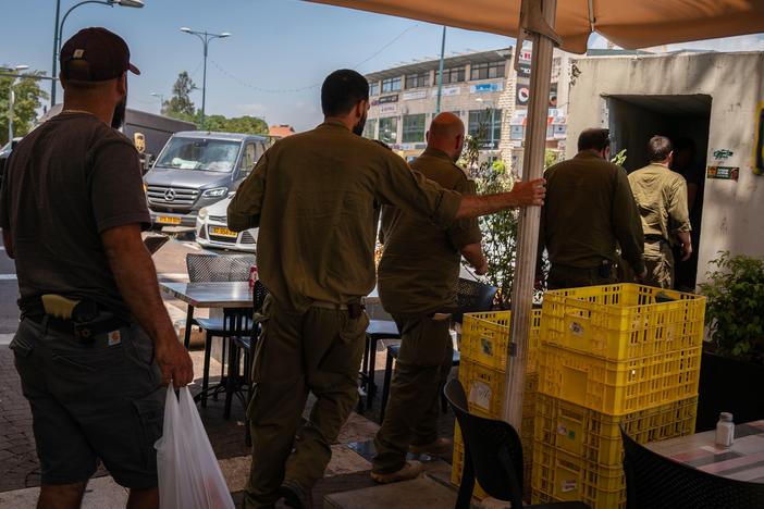 Soldiers and civilians enter a rocket shelter as sirens sound in the Israeli town of Kiryat Shmona on the Lebanese border on June 10.