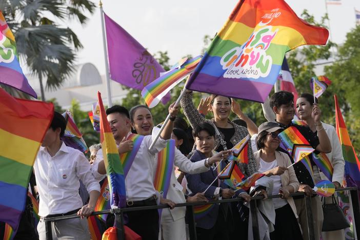 Participants wave flags celebrating marriage equality at the government house in Bangkok, Thailand, Tuesday. Thailand's Senate voted overwhelmingly to approve a marriage equality bill.