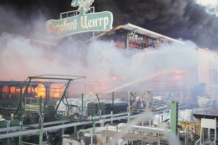 Firefighters try to put out a fire after two guided bombs hit the Epicenter shopping complex in Kharkiv, Ukraine, on Saturday, May 25, 2024. The sign reads "Garden Center."