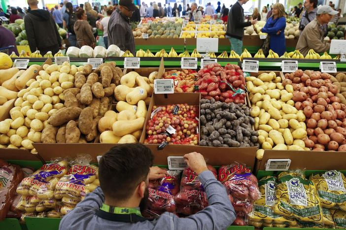 An employee arranges a digital price tag for vegetables at the Whole Foods store in the Silver Lake neighborhood of Los Angeles.