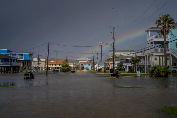 A rainbow appears behind a flooded neighborhood in Jamaica Beach, Texas, on Thursday.