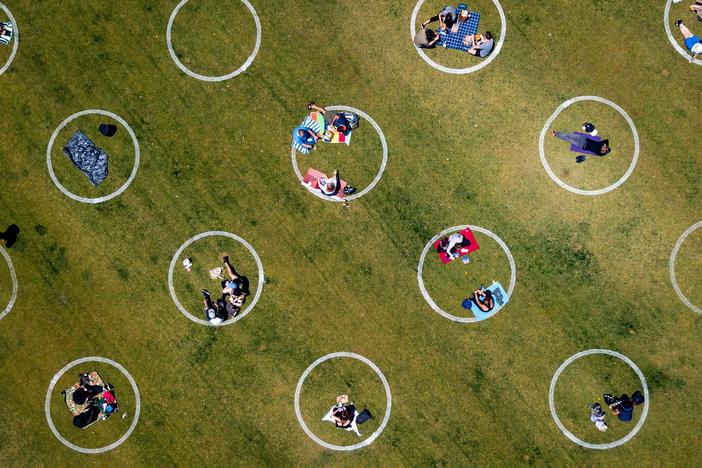An aerial view shows painted circles in the grass to encourage people to keep a distance from each other at Washington Square Park in San Francisco. The photo is from May 22, 2020.