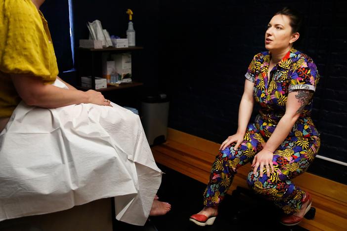 Dr. Stephanie Arnold, who prefers bright-colored clothes instead of a white coat, meets with a patient who needs a pelvic exam. The family medicine clinic Arnold founded offers reproductive health care, including abortion, alongside all kinds of other care. “It’s a little bit of everything, which is very typical of family medicine,” she says.