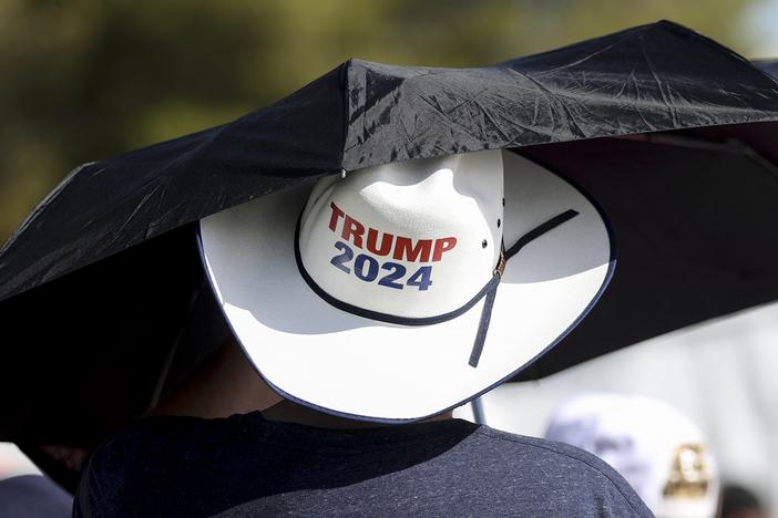 A man uses an umbrella at a campaign rally for former President Donald Trump on June 9 in Las Vegas, where temperatures climbed above 100 degrees. 