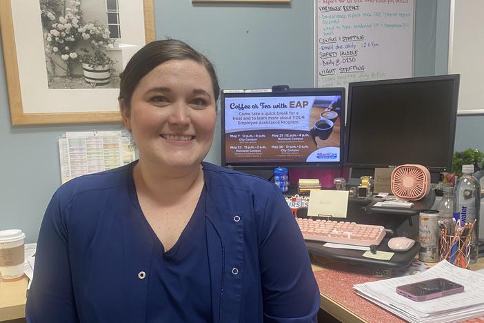 Nurse manager Danielle DiLella sits in her office, with a long to-do list on her whiteboard behind her.