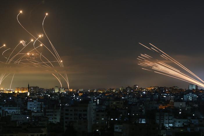 Israel's Iron Dome missile defense system (left) intercepts rockets (right) fired by Palestinian militants from Gaza on May 14, 2021. Over the years, Iron Dome has stopped thousands of rockets headed for Israeli cities, but experts warn that in a war with Hezbollah, new tactics and sheer numbers could cause it to fail.