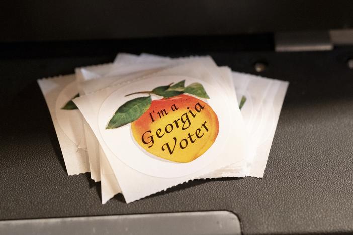 A stack of stickers sits atop a ballot scanner during the midterm elections on Nov. 8, 2022, in Tucker, Georgia. In 2024, Georgia is poised to play a pivotal role in the outcome of the presidential election. 