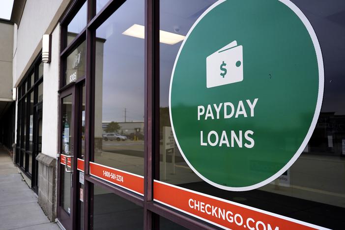 A "payday loans" sign is displayed at a Check 'n Go in Niles, Ill., in 2021.