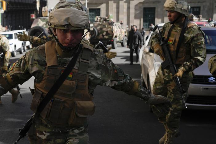 A soldier gestures for journalists to leave Plaza Murillo as soldiers gather outside the presidential palace in Plaza Murillo in La Paz, Bolivia, on Wednesday. Bolivian President Luis Arce warned that an “irregular” deployment of troops was taking place in the capital, raising concerns that a potential coup was underway. 