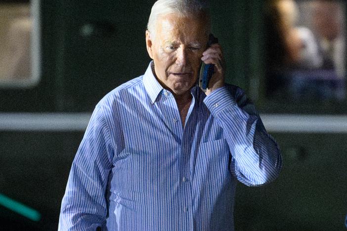 President Biden speaks on the phone while walking to board Air Force One after a fundraiser in New Jersey on Saturday.