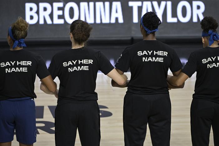 Minnesota Lynx players lock arms during a moment of silence in honor of Breonna Taylor before a game  in July 2020.