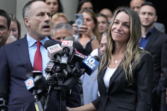 Karen Read, right, smiles as defense attorney David Yannetti, front left, speaks to reporters in front of Norfolk Superior Court in Dedham, Mass., after the judge declared a mistrial on Monday.