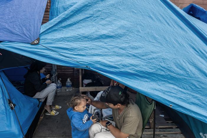 A homeless family with a two-year-old child on Towne Avenue in Los Angeles' Skid Row in April 2024. A new study tracks how housing insecurity affects children's health as they grow. 